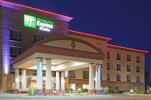 Un hotel Holiday Inn Express & Suites con entrada techada y fachada de ladrillo.