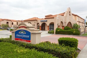 Edificio de Howard Johnson Inn & Suites con un letrero de recepción, ventanas en arco y techo de tejas.