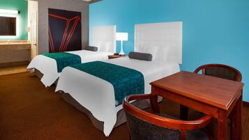 Une chambre d’hôtel avec deux lits, un bureau et une chaise.