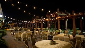 An outdoor dining area with string lights, tables, and chairs. - Hilton Dallas/Southlake Town Square (Southlake)
