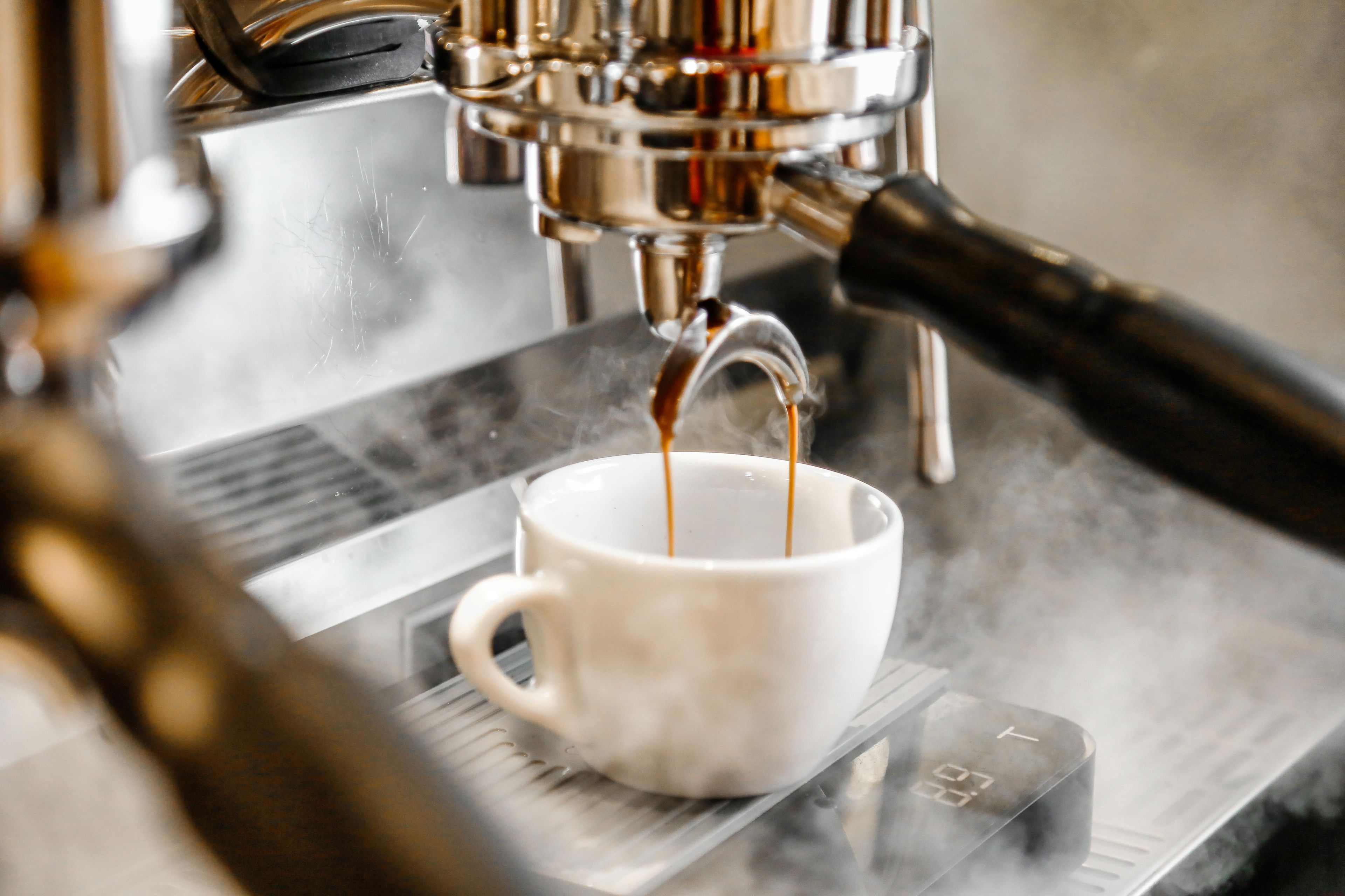 Une machine à café qui verse du café dans une tasse.