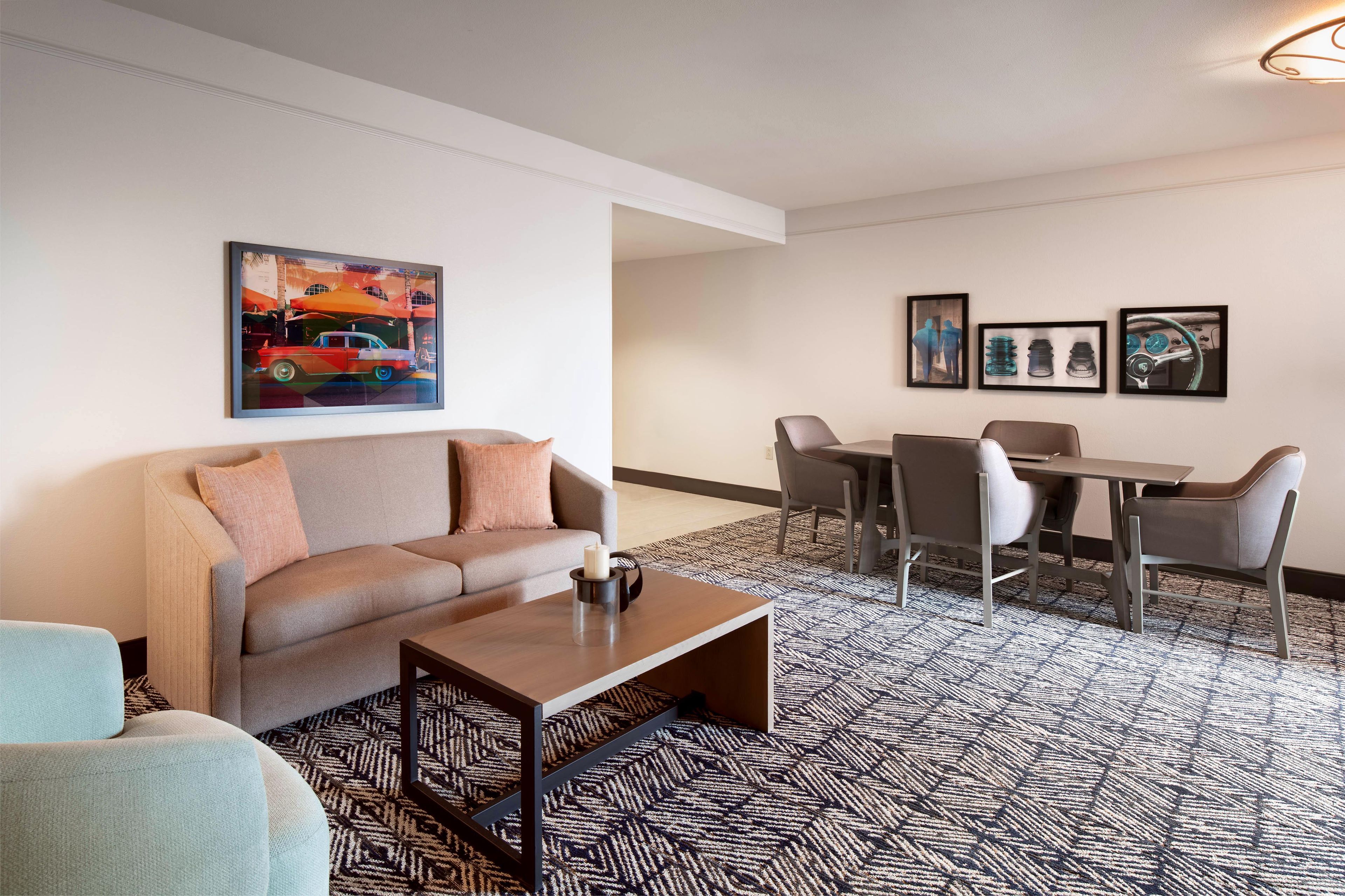 Ein modernes Wohnzimmer mit Sofa, Couchtisch und Essbereich mit Stühlen und Tisch.
