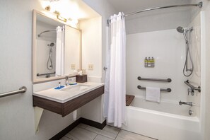 A modern bathroom with a sink, mirror, and shower.