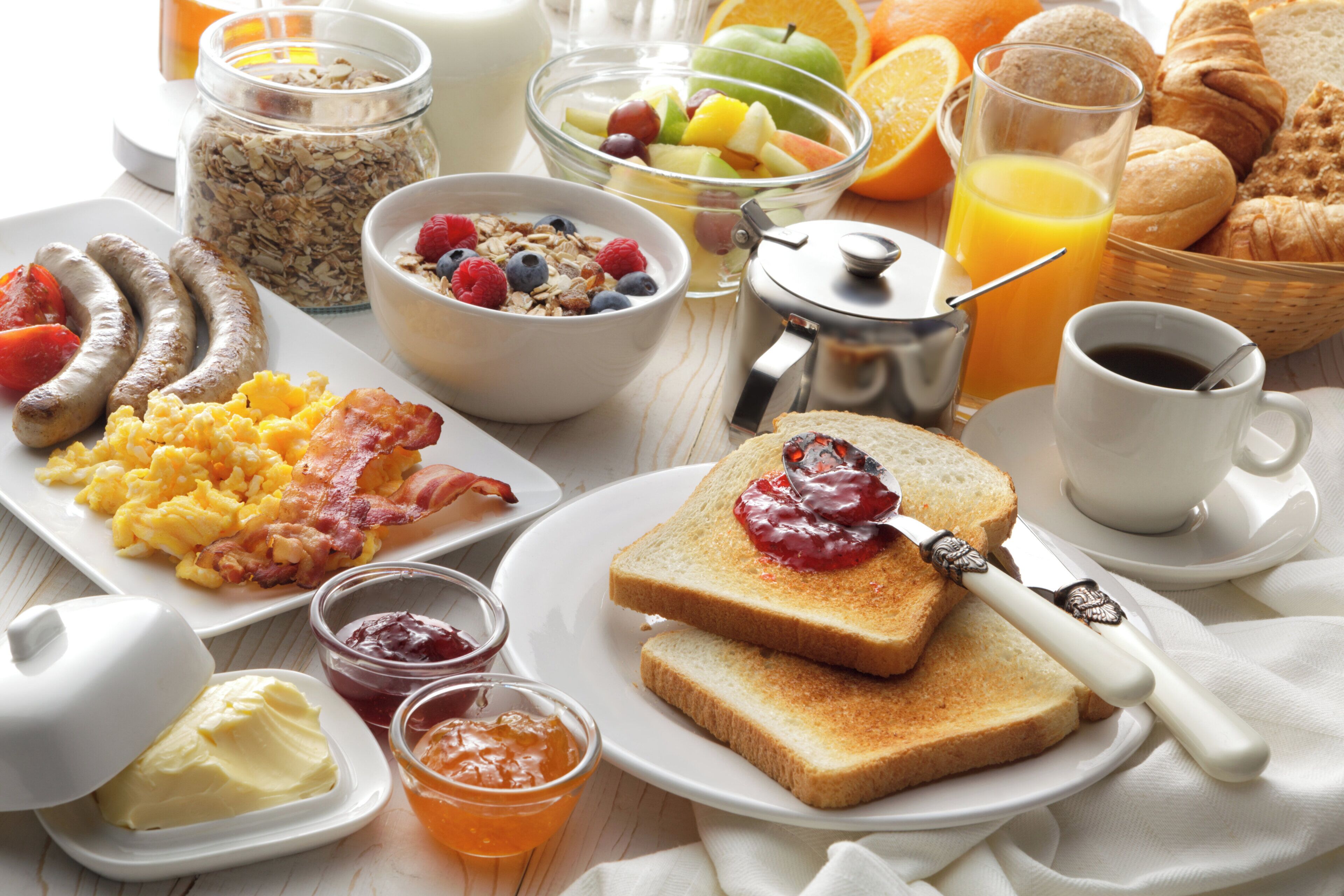 Une table dressée pour le petit-déjeuner, avec divers aliments et boissons.