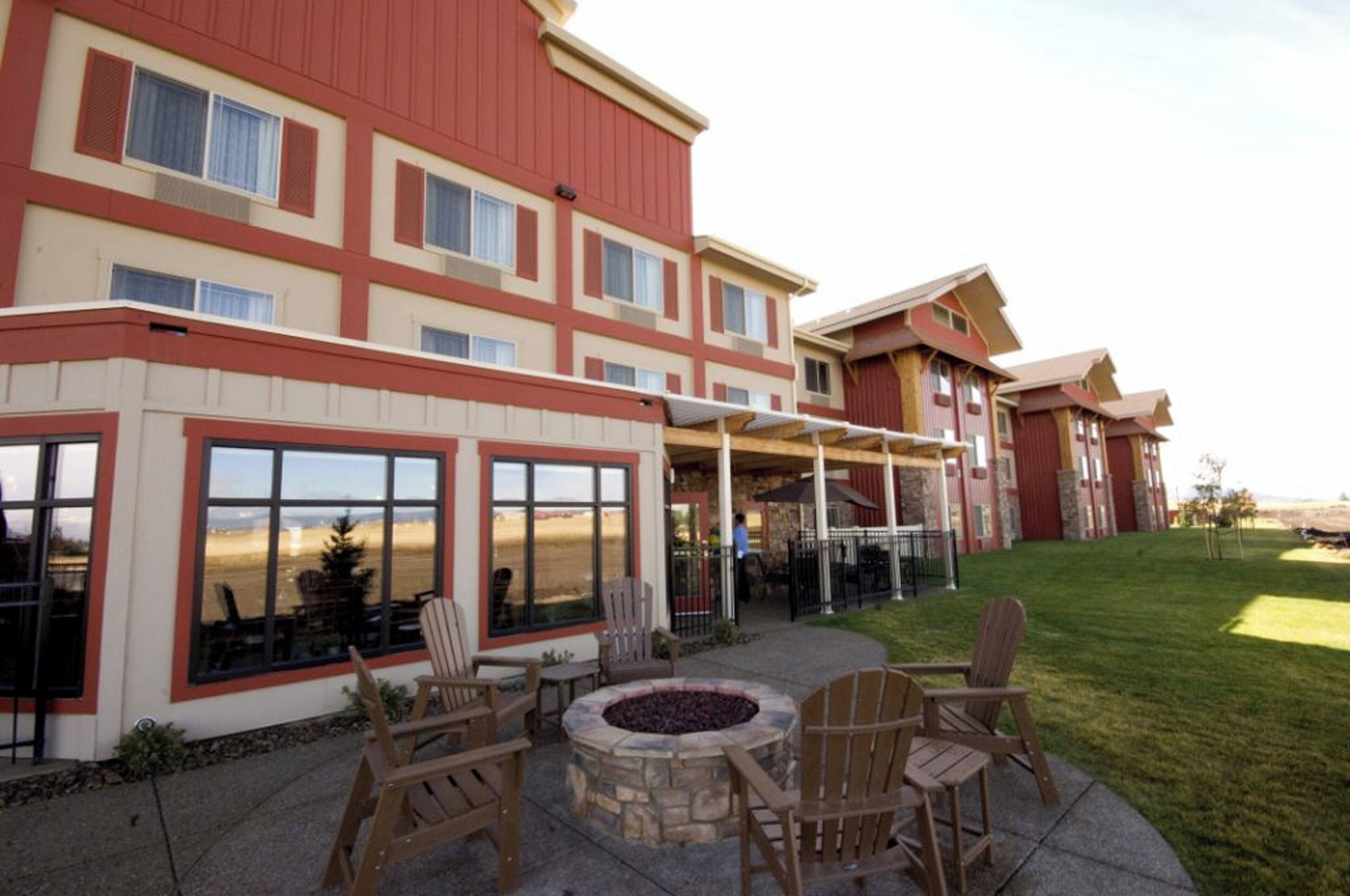 Ein Hotel mit einer Terrassenanlage, die Sitzgelegenheiten im Freien und eine Feuerstelle bietet.