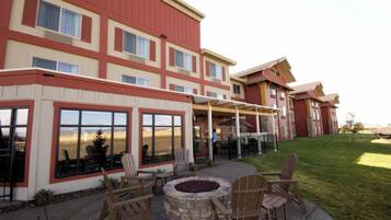 Un hotel con un patio amueblado con mobiliario exterior y una chimenea.