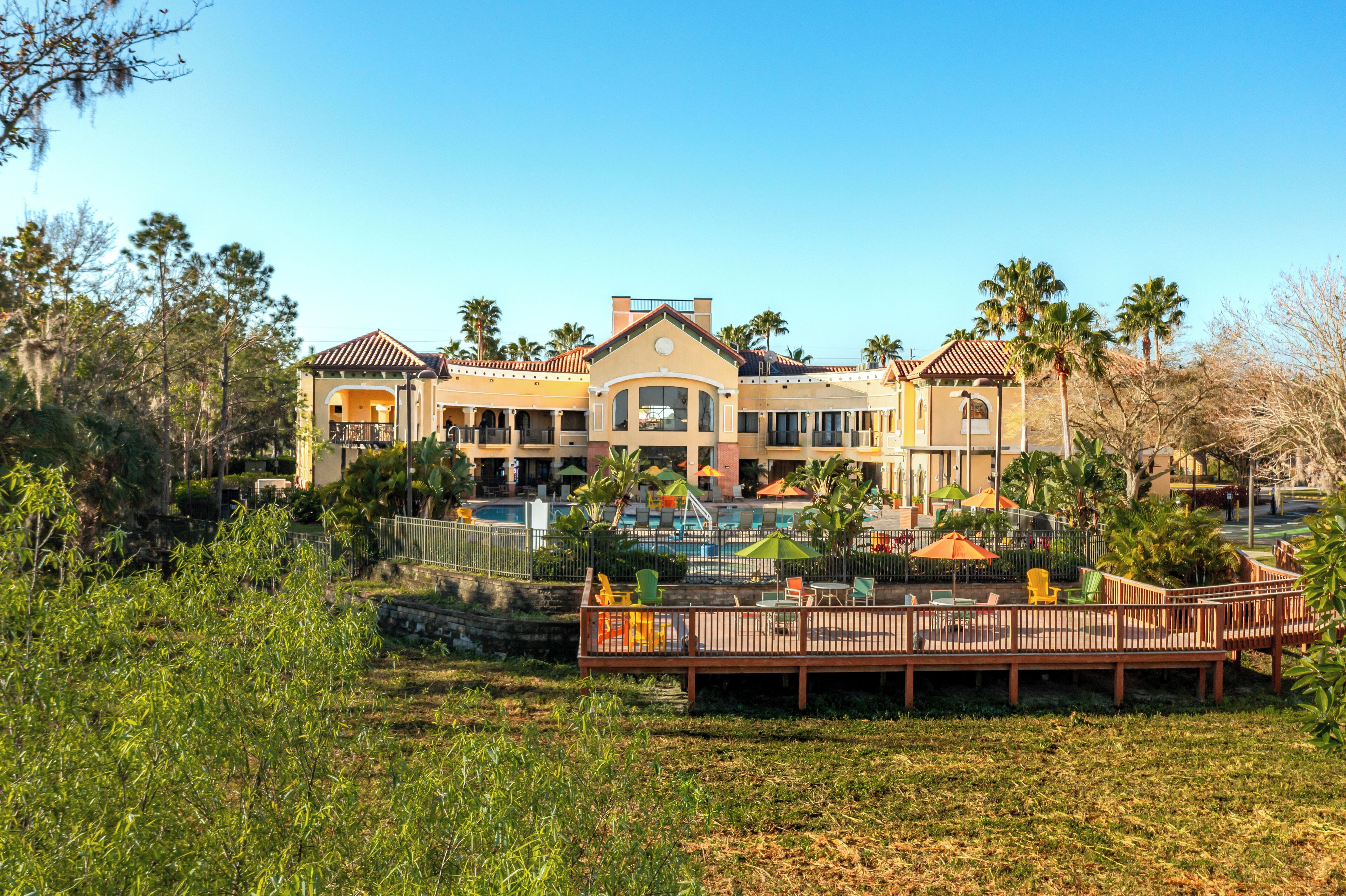 A resort with a pool, outdoor seating, and a large building with multiple balconies.
