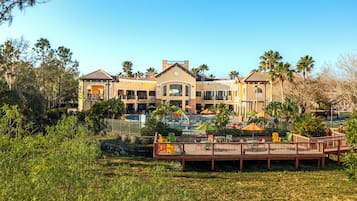 A resort with a pool, outdoor seating, and a large building with multiple balconies.
