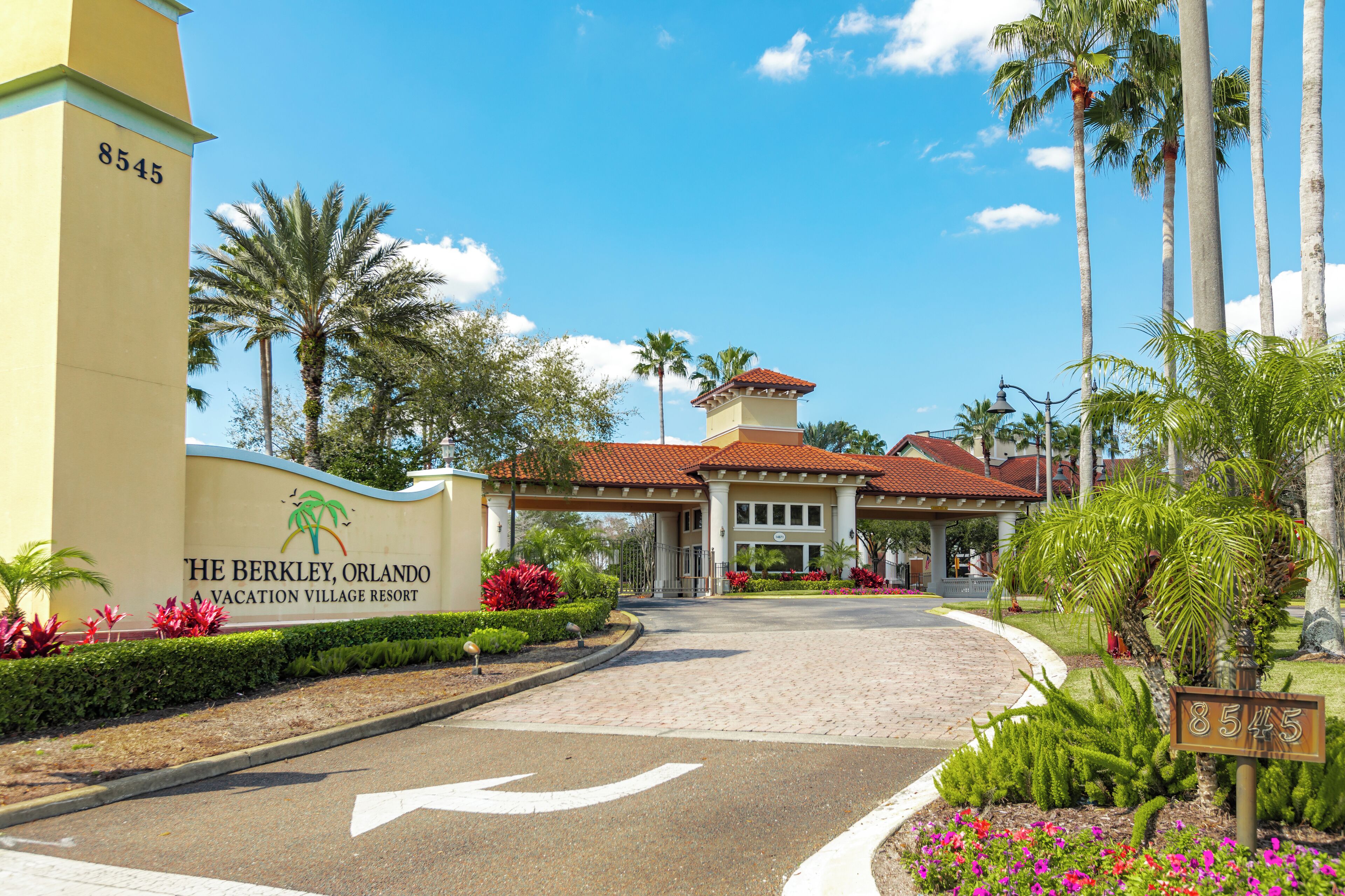 De ingang van een resort met een bord waarop staat: "The Berkley, Orlando A Vacation Village Resort" en het getal "8545" op een gebouw.