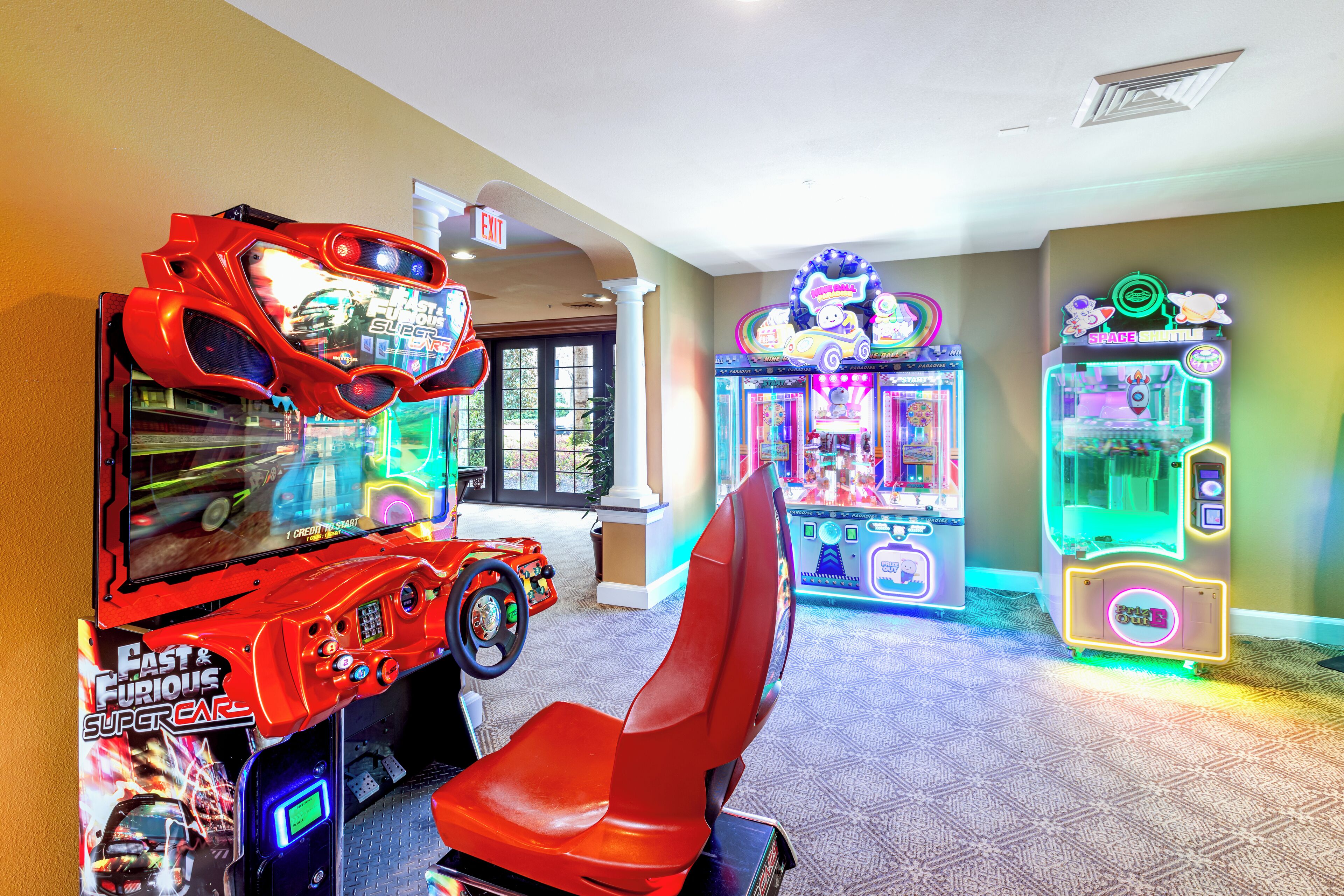 A row of arcade games including a 'Cast & Furious Super Car' game, a claw machine, and a racing game.