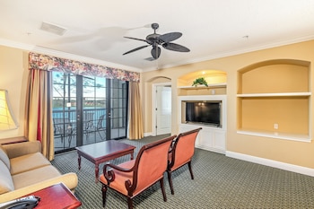 A gym with treadmills, elliptical machines, and stationary bikes, large windows, and a view of the outside. at The Berkley, Orlando