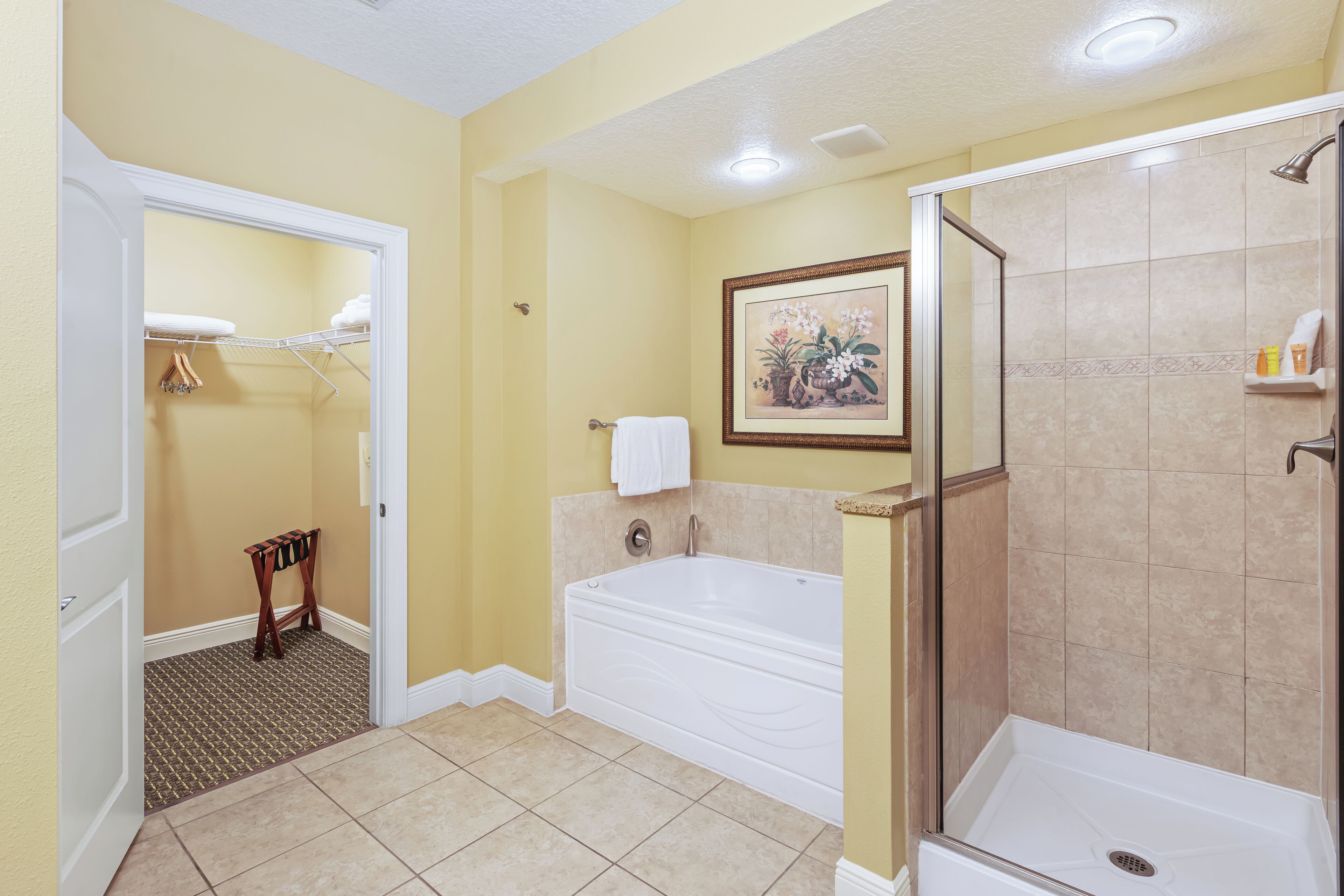 A bathroom with a bathtub, shower, and a small vanity area.