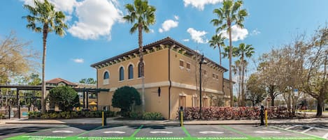 A building with a beige facade, arched windows, and a flat roof.