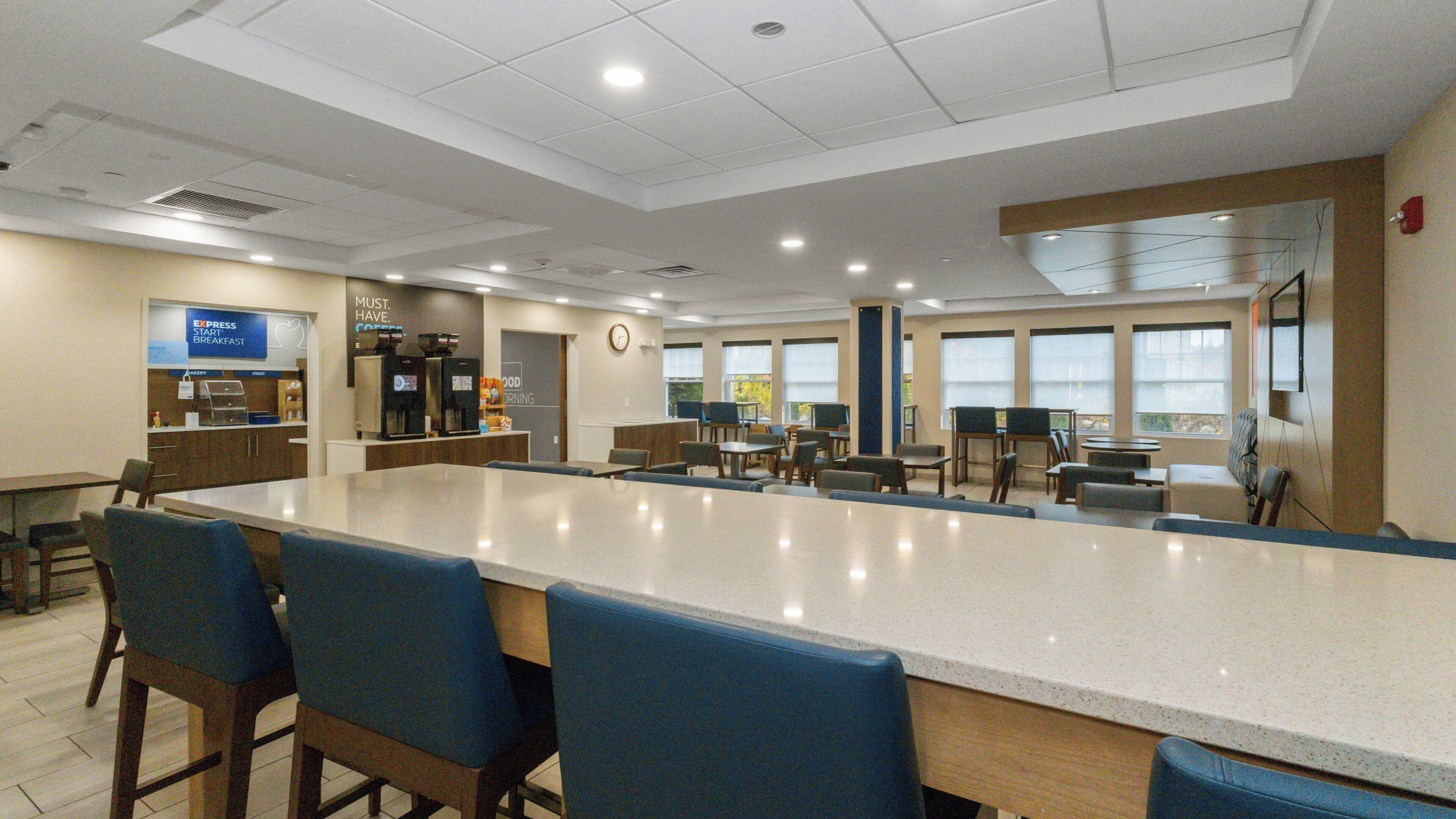 A spacious dining area with a long counter, multiple tables, and chairs.