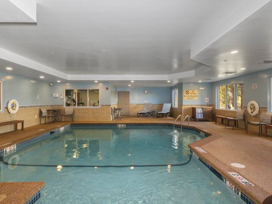 En indendørs swimmingpool med flisearm, en redningsbøje og en bænk.