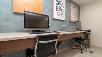 A modern office desk with a computer, keyboard, mouse, and chair.