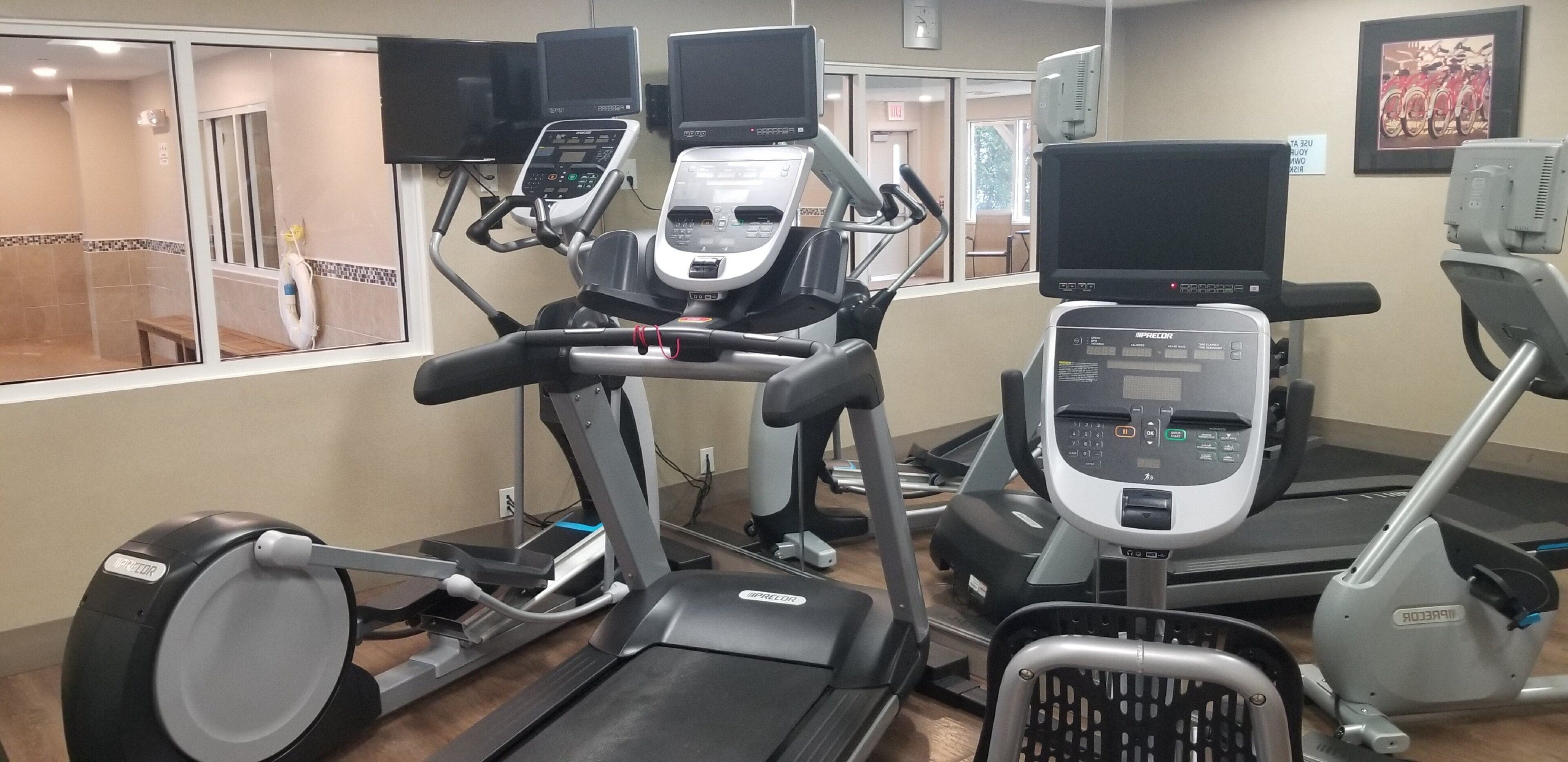 Una palestra dotata di diverse macchine per allenamento, tra cui tapis roulant ed ellittiche.