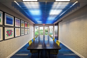 A conference room with a long table, yellow chairs, and framed artwork on the walls. - Holiday Inn Express & Suites Schererville by IHG (Schererville)
