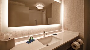 A modern bathroom with a large mirror, a sink, and a toilet. - Holiday Inn Express & Suites Schererville by IHG (Schererville)