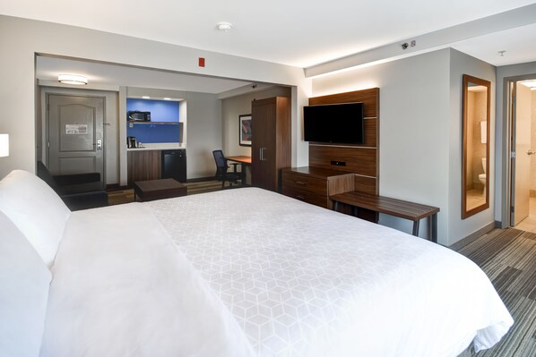 A hotel room with a large bed, a desk, a television, and a kitchenette. - Holiday Inn Express & Suites Schererville by IHG (Schererville)