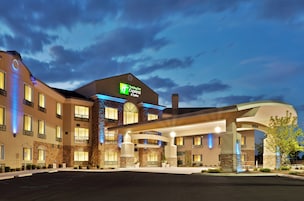 Un hotel Holiday Inn Express & Suites con un diseño moderno, que cuenta con una entrada amplia y numerosas ventanas.
