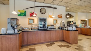 A breakfast bar with a clock, coffee machines, and various food items. - Quality Inn Kenai (Kenai)