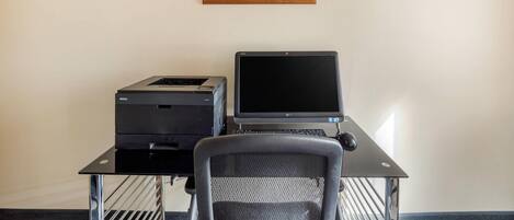 A workspace with a Dell printer, an Epson printer, and a laptop on a black desk.