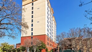 A tall hotel with a sign reading "Staybridge Suites". It has multiple floors and a mix of brick and beige exterior. - Staybridge Suites San Antonio Downtown Conv Ctr by IHG (San Antonio)