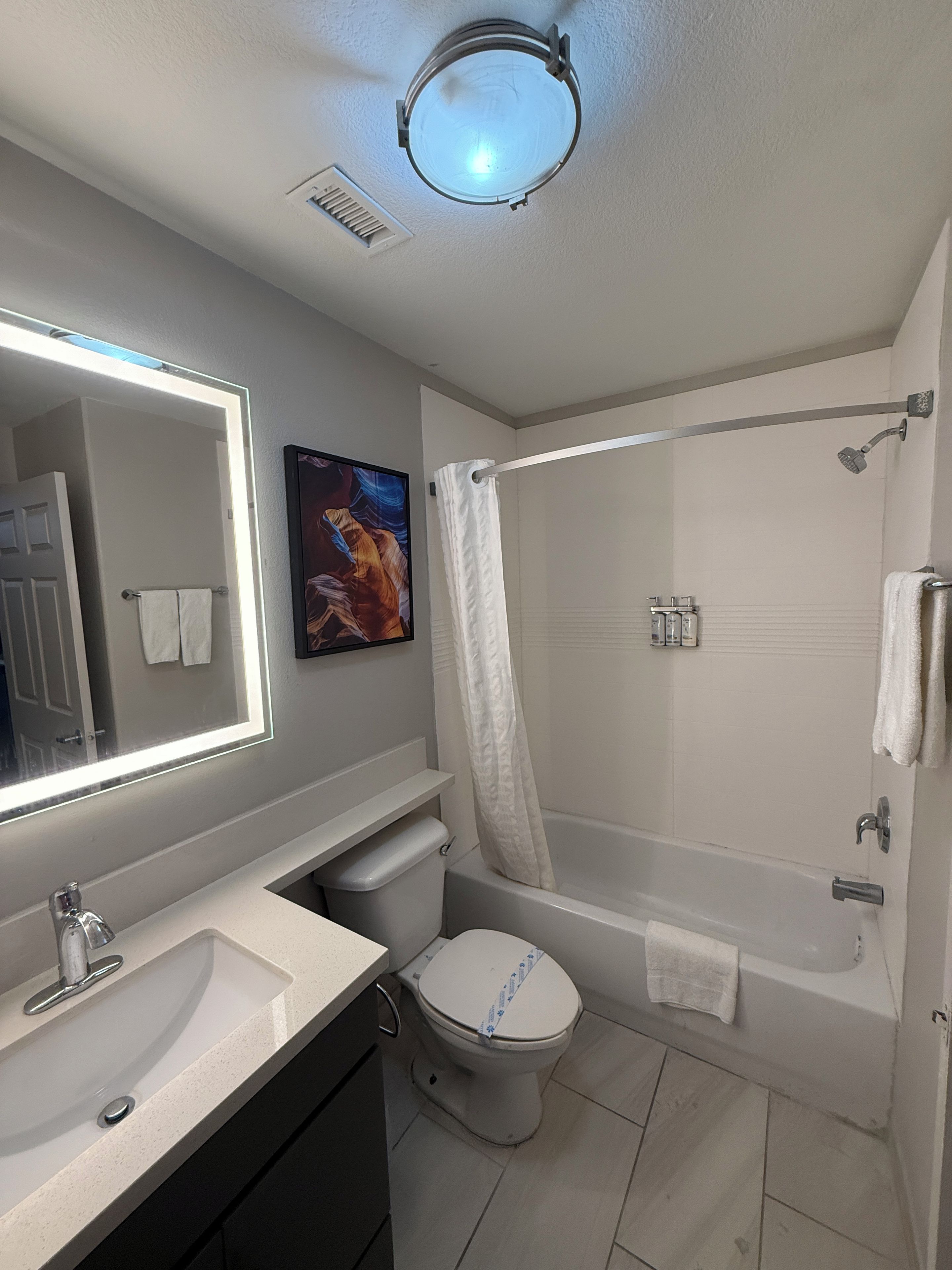 A modern bathroom with a toilet, sink, and shower.