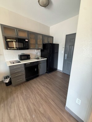 A kitchen with a microwave, oven, sink, and refrigerator. - Candlewood Suites Corpus Christi-Spid by IHG (Corpus Christi)