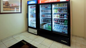 A vending machine area with two beverage dispensers, one labeled 'Candlewood Cupboard' and the other 'Coca-Cola.'
