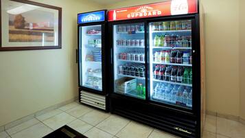 Un espace comprenant des distributeurs automatiques, avec deux appareils à boissons : l’un est étiqueté « Candlewood Cupboard » et l’autre « Coca-Cola ».