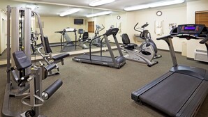 A gym with various exercise equipment including treadmills, elliptical machines, and weight machines.