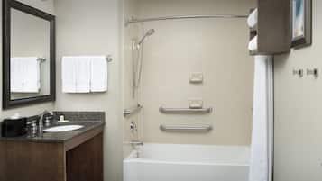 A bathroom with a sink, mirror, towel rack, shower, and bathtub.