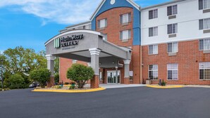 Een MainStay Suites hotel met een bakstenen gevel, een overdekte ingang en een parkeerplaats.
