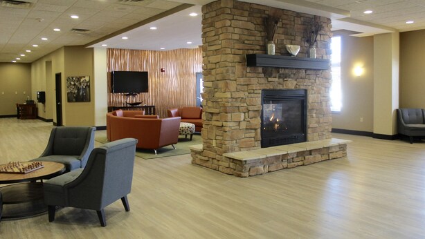 Een ruime lobby met een stenen openhaard, comfortabele zitplaatsen en een flatscreen-televisie.