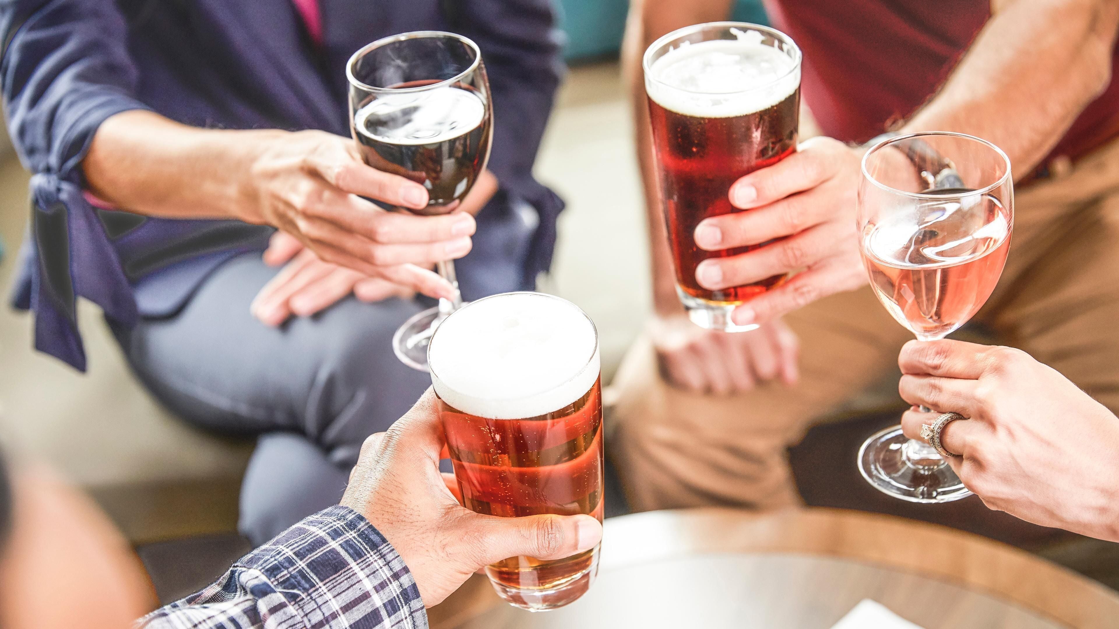 Een groep mensen met bierglazen, waarschijnlijk in een sociale omgeving.