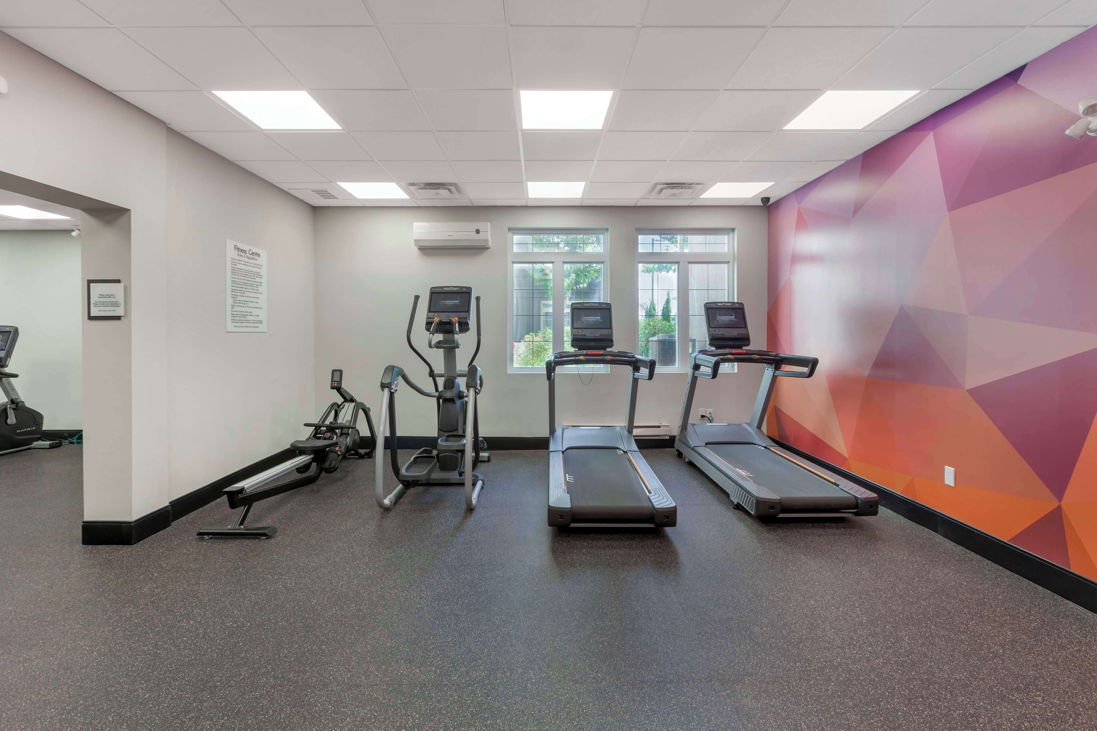 A gym with treadmills, elliptical machines, and a stationary bike.
