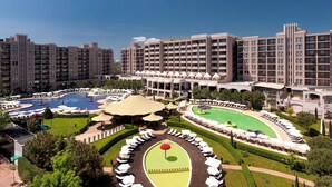 A hotel with multiple high-rise buildings, a central courtyard with a swimming pool, and outdoor seating areas. - Barceló Royal Beach – All Inclusive (Sunny Beach)