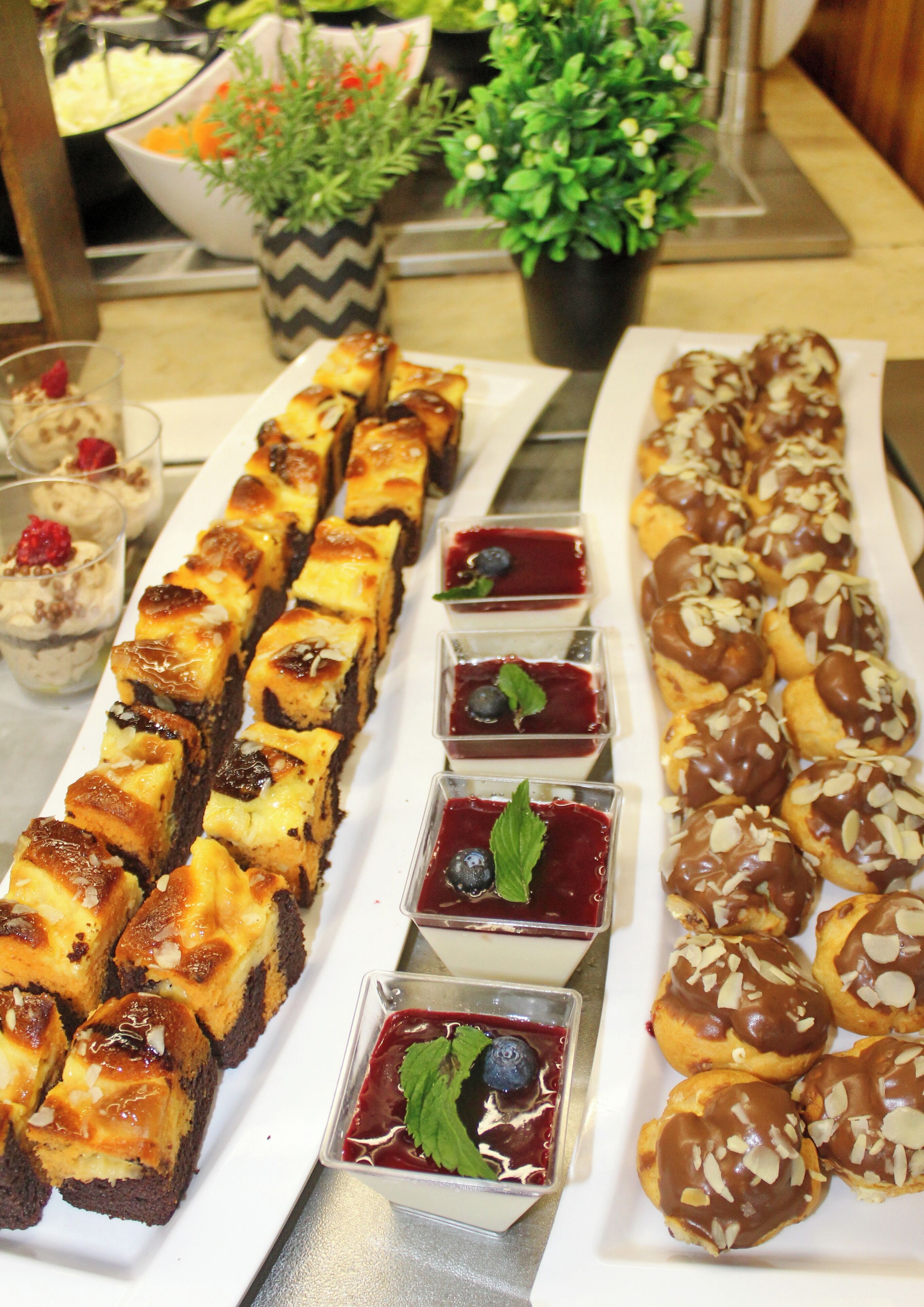 Ein Buffet mit verschiedenen Desserts, darunter Kuchen, Gebäck und Obsttorten.