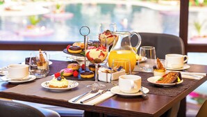 A breakfast table with various pastries, a pitcher of orange juice, and cups and saucers. - Barceló Royal Beach – All Inclusive (Sunny Beach)