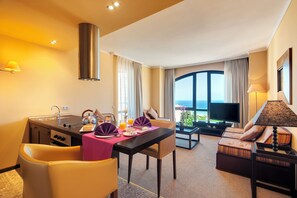 A hotel room with a dining area, a sofa, a TV, and a balcony with a view. - Barceló Royal Beach – All Inclusive (Sunny Beach)