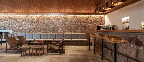 A stone wall bar area with seating and a stone floor.