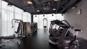 A gym with exercise equipment, large windows, and a clock on the wall. - Park Plaza Amsterdam Airport (Lijnden)