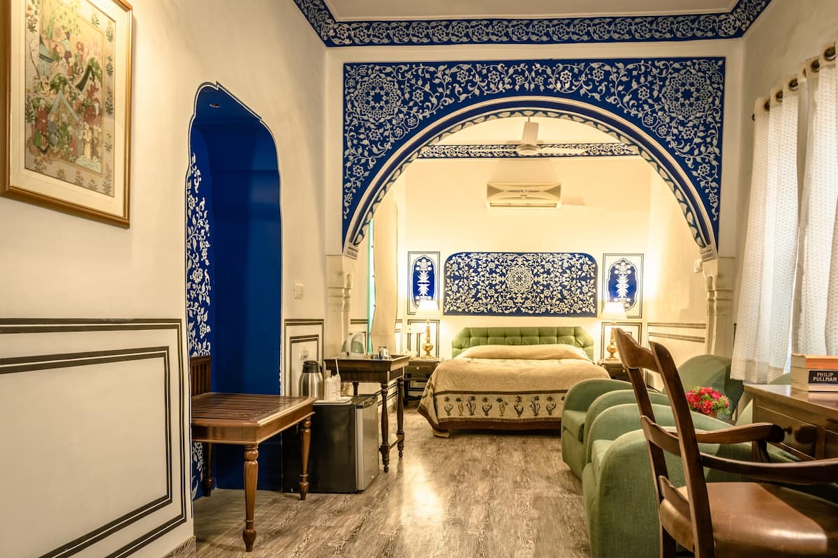 Ein Schlafzimmer mit Bett, Schreibtisch, Stuhl und Tisch.