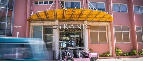 A hotel with a prominent yellow awning and a sign that reads 'GRAND HOTEL AND CASINO'.