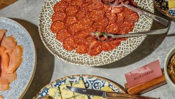 A table with various food items including sliced meats, cheeses, and grapes.