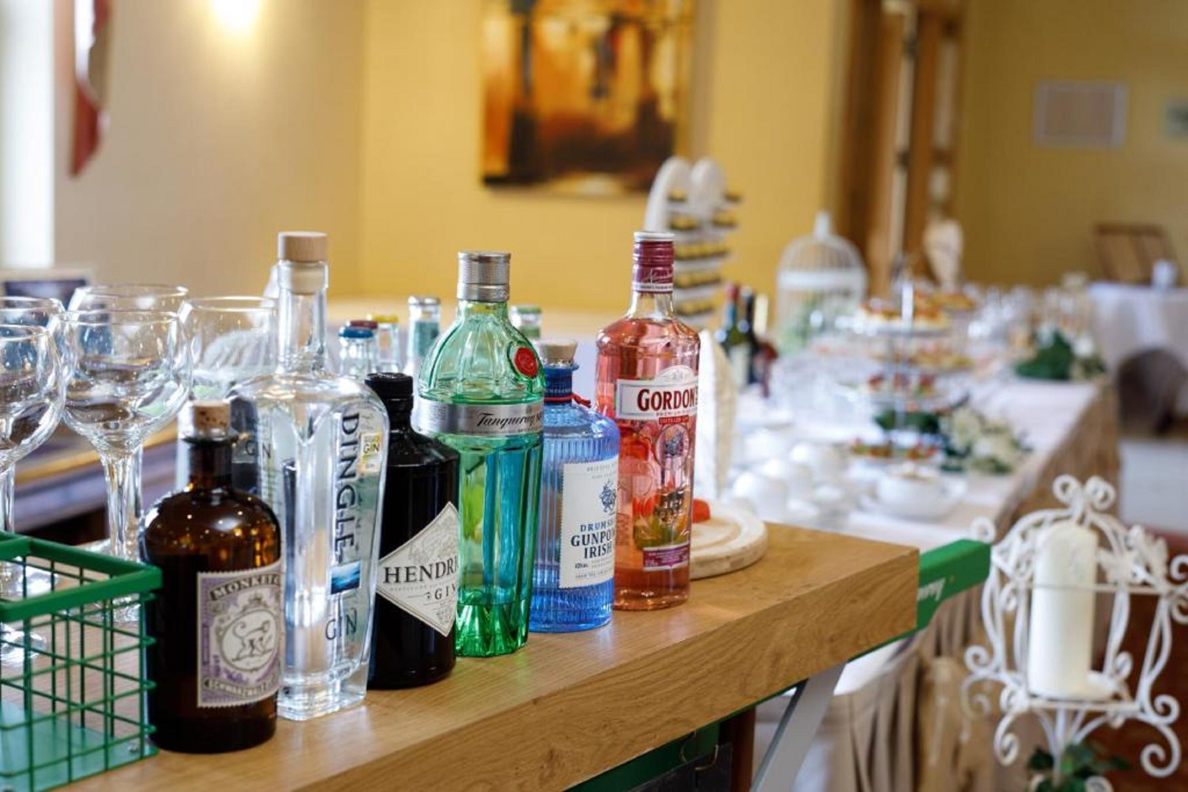 A bar area with various bottles of liquor and glasses on a wooden counter.