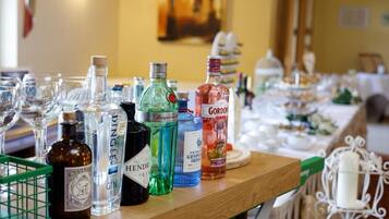 A bar area with various bottles of liquor and glasses on a wooden counter.