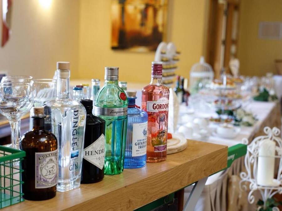 A bar area with various bottles of liquor and glasses on a wooden counter.